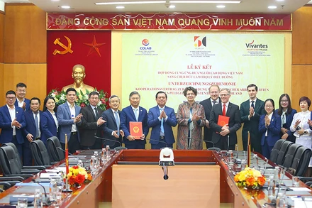 Thứ trưởng Nội vụ Nguyễn Bá Hoan và Đại sứ CHLB Đức tại Việt Nam Helga Margarete Barth cùng chứng kiến lễ ký kết hợp đồng giữa hai đơn vị. (Ảnh Moha)