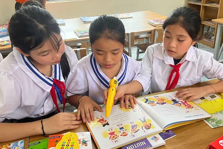 Học sinh Trường Phổ thông dân tộc bán trú tiểu học Mai Sơn đọc sách tại thư viện mới. (Ảnh NFVC) 