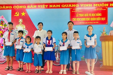 Các đồng chí Đỗ Ái Lam, Phó Chủ tịch Ủy ban nhân dân thành phố Bạc Liêu (nữ) và Trưởng phòng Giáo dục và Đào tạo thành phố Bạc Liêu Trần Bằng Phi trao quà, học bổng các em học sinh khó khăn, hiếu học.