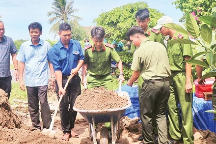 Lực lượng Công an tỉnh Sóc Trăng giúp đỡ xây dựng nhà cho các hộ nghèo.