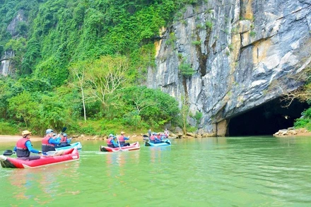 Du khách chèo kayak khám phá động Phong Nha. (Ảnh: Báo Nhân Dân)