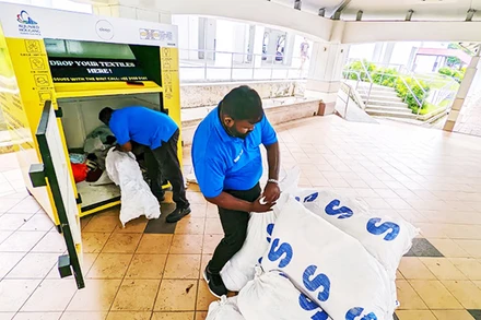 Nhân viên LifeLine thu gom quần áo trong các thùng rác tái chế. Ảnh: CHANNEL NEWS ASIA