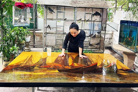 Họa sĩ đang hoàn thành một bức tranh khổ lớn.