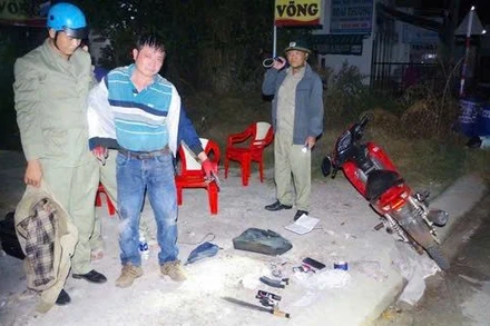 Lực lượng công an bắt đối tượng cùng hung khí. (Ảnh: Công an Bình Phước)