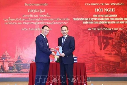 Đồng chí Lê Hoài Trung, Bí thư Trung ương Đảng, Chánh Văn phòng Trung ương Đảng tặng sách cho đồng chí đồng chí Thongsalith Mangnomek, Bí thư Trung ương Đảng, Chánh Văn phòng Trung ương Đảng Nhân dân Cách mạng Lào. (Ảnh: TTXVN) 