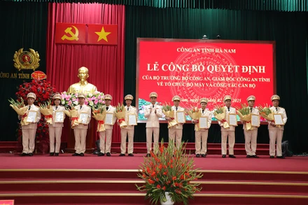 Đồng chí Giám đốc Công an tỉnh Hà Nam trao quyết định, tặng hoa chúc mừng các đồng chí lãnh đạo cấp phòng nhận công tác mới.