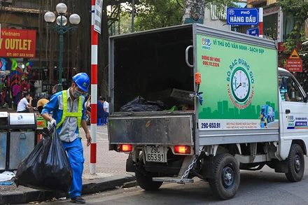 Công nhân Công ty Môi trường đô thị Hà Nội thu gom rác thải trên địa bàn quận Hoàn Kiếm. (Ảnh PHẠM HÙNG)