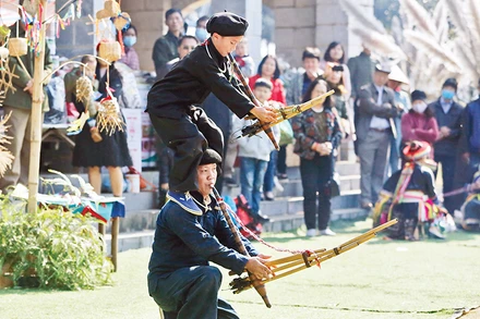 Hai cha con diễn tấu khèn tại một phiên chợ. 