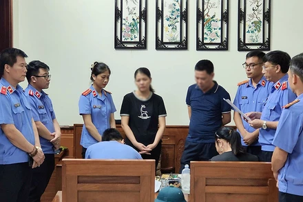 Cơ quan điều tra Viện Kiểm sát nhân dân tối cao thi hành lệnh bắt bị can, tạm giam đối với bà Trần Thị Hoa (thứ 4 từ trái sang), chấp hành viên thuộc Chi cục Thi hành án dân sự thành phố Yên Bái. (Ảnh Văn Thành)