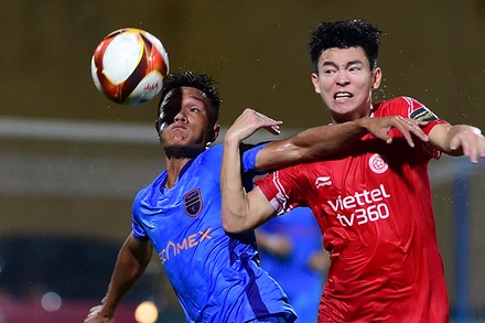 Pha tranh bóng giữa cầu thủ hai đội Viettel FC (áo đỏ) và Becamex Bình Dương. (Ảnh THANH HẢI)