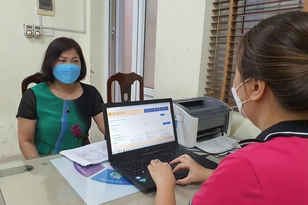 Hỗ trợ phụ huynh đăng ký tuyển sinh trực tiếp tại Trường tiểu học Nghĩa Tân, quận Cầu Giấy, Hà Nội. (Ảnh Thùy Dung)