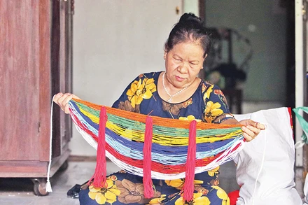 Bà Hồ Thị Non giới thiệu vòng cườm đá đeo ở lưng của người Cor. 