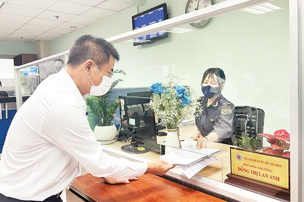 Cán bộ Hải quan Thành phố Hồ Chí Minh hướng dẫn thủ tục khai thuế cho doanh nghiệp. (Ảnh Cục Hải quan thành phố)