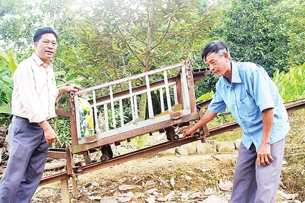 Một phần hệ thống máy vận chuyển trên địa hình dốc của ông Trần Văn Túy (bên phải).