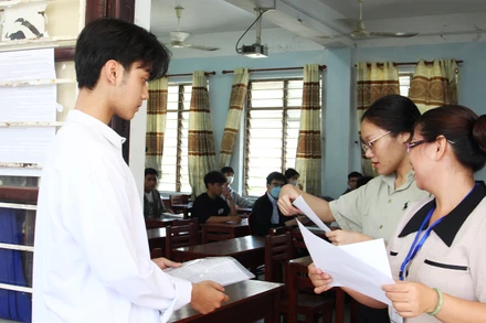 Giám thị kiểm tra thông tin thí sinh trước khi vào phòng thi.