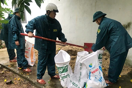 Chuẩn bị các bao cát để chằng chống mái nhà.