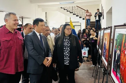 Đại sứ Vũ Trung Mỹ và các đại biểu tham quan triển lãm ảnh Việt Nam-Hồ Chí Minh. (Ảnh: Đại sứ quán Việt Nam tại Venezuela)