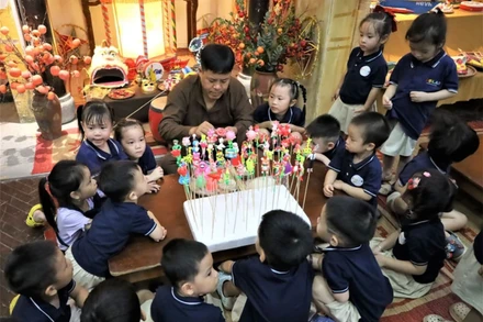 Các em nhỏ say sưa bên nghệ nhân nặn tò he tại Hoàng thành Thăng Long.