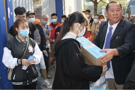 Các sinh viên, người lao động nhận quà Tết trước khi lên xe về quê vào ngày 25 tháng Chạp.