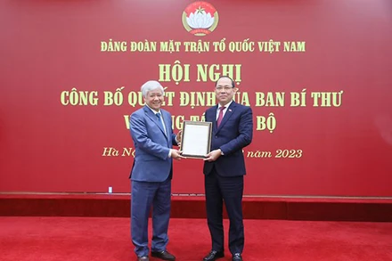 Đồng chí Đỗ Văn Chiến trao Quyết định và tặng hoa chúc mừng đồng chí Hoàng Công Thủy. (Ảnh: DIỆP VINH)
