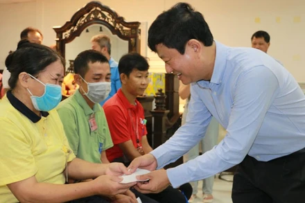 Chủ tịch Ủy ban nhân dân tỉnh Bình Dương Võ Văn Minh trao tặng quà cho công nhân lao động Công ty TNHH Công nghiệp KingJade Việt Nam.