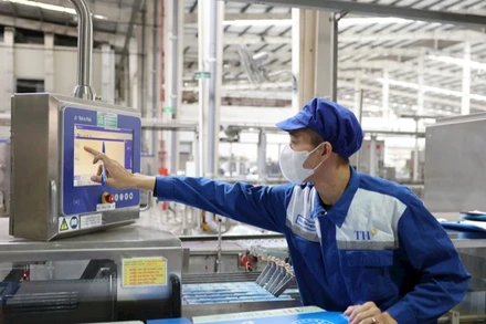 Công nhân vận hành hệ thống công nghệ hiện đại tại Nhà máy sữa TH, góp phần giảm phát thải khí nhà kính.