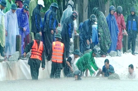 Bộ đội, dân quân tích cực giúp địa phương đắp đê chống sạt lở bờ đê Mai Dương (huyện Quảng Điền).