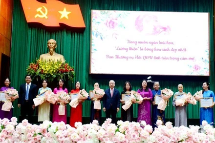 Lãnh đạo tỉnh tặng hoa chúc mừng 10 gương mặt “Phụ nữ tiêu biểu vì cộng đồng” được tuyên dương năm nay.