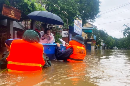 Cán bộ, chiến sĩ ngâm mình trong nước di dời người dân vùng ngập lũ ở Huế.