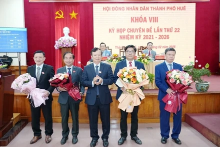 Bí thư Thành ủy Huế Lê Trường Lưu tặng hoa chúc mừng đồng chí Nguyễn Chí Tài vừa bầu bổ sung Phó Chủ tịch Ủy ban nhân dân thành phố (thứ 2 từ bên phải) và các đồng chí vừa chuyển công tác. (ảnh: Ng.Hiếu)