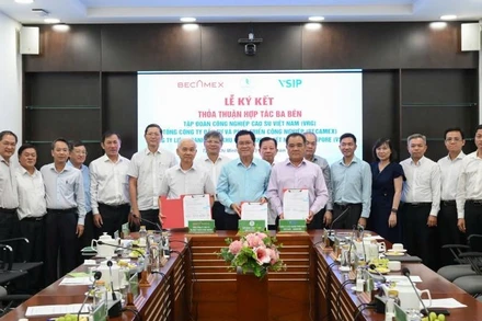 Lãnh đạo Tập đoàn Công nghiệp cao su Việt Nam, Becamex và Công ty Liên doanh Trách nhiệm hữu hạn Khu công nghiệp Việt Nam-Singapore trao bản ký kết thỏa thuận hợp tác.