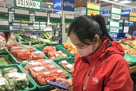 Người tiêu dùng kiểm tra thông tin, nguồn gốc hàng hóa thông qua việc quét mã QR tại một siêu thị ở thành phố Buôn Ma Thuột, tỉnh Đắk Lắk. (Ảnh: ĐỖ LAN)