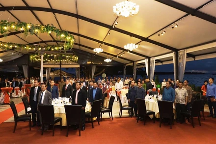 Các đại biểu và khách mời làm lễ chào cờ.