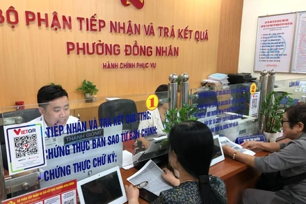 Người dân thực hiện thủ tục hành chính tại Bộ phận một cửa phường Đồng Nhân, quận Hai Bà Trưng, Hà Nội.