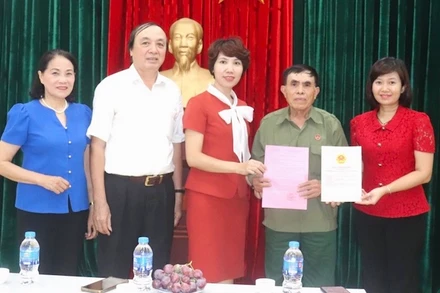 Lãnh đạo Văn phòng Hội đồng nhân dân và Ủy ban nhân dân quận Hai Bà Trưng, phường Vĩnh Tuy trao Giấy chứng nhận quyền sử dụng đất-quyền sở hữu nhà và giấy phép xây dựng cho gia đình ông Đặng Ngọc Tuy.