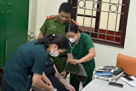 Cán bộ y tế phường Yên Phụ kiểm tra tình trạng sức khỏe và động viên tinh thần người phụ nữ.