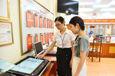 Cán bộ Ủy ban nhân dân phường Thanh Xuân Nam (quận Thanh Xuân, Hà Nội) hướng dẫn người dân thực hiện thủ tục hành chính trên môi trường mạng. Ảnh: Thuỷ Nguyên.