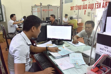 Giải quyết thủ tục hành chính cho người dân tại Bộ phận “một cửa” xã Hữu Hòa, huyện Thanh Trì (Hà Nội). Ảnh: Duy Linh. 