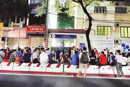 Phụ huynh học sinh xếp hàng chờ mua hồ sơ cho con nhập học vào trường Trung học phổ thông Tạ Quang Bửu, Hà Nội. (Ảnh: Trang Linh)