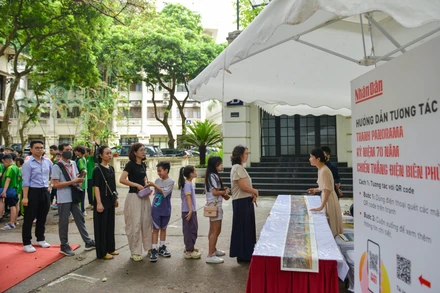 Bạn đọc xếp hàng để nhận ấn bản đặc biệt của Báo Nhân Dân in tranh panorama Chiến dịch Điện Biên Phủ.