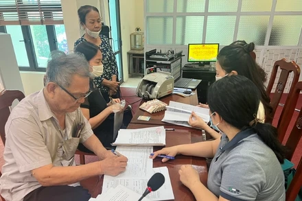 Người dân xã Đắc Sở, huyện Hoài Đức, Hà Nội, nhận tiền đền bù tại trụ sở UBND xã, sáng 12/5/2023. (Ảnh: Trần Thụ)