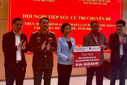 Bà Phạm Thị Thanh Mai, Phó trưởng đoàn chuyên trách Đoàn Đại biểu Quốc hội thành phố Hà Nội, trao kinh phí mua áo ấm tặng học sinh nghèo huyện Mường Nhé.