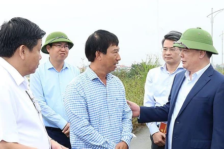 Đồng chí Đinh Tiến Dũng trò chuyện với người dân có đất nằm trong dự án Vành đai 4-Vùng Thủ đô trên địa bàn huyện Hoài Đức.