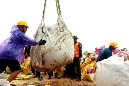 Cán bộ, nhân dân và các lực lượng vũ trang đang hỗ trợ chính quyền đắp đê gia cường bảo vệ bờ biển xã Phú Thuận sáng 11/10/2022.