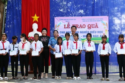 Đại diện nhà tài trợ và lãnh đạo huyện Bác Ái trao quà cho học sinh dân tộc thiểu số Raglai vượt khó học giỏi.