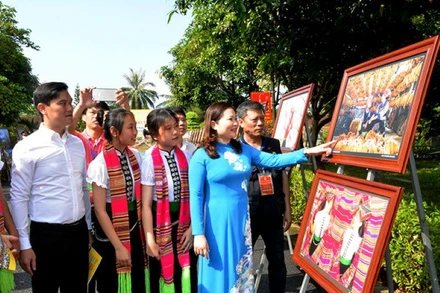 Các đại biểu và học sinh tham quan triển lãm ảnh.