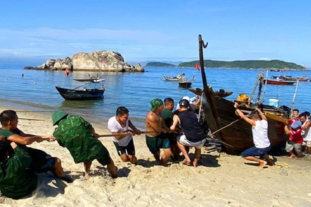 Lực lượng cứu hộ kéo tàu cá QNa-02211 lên bờ.