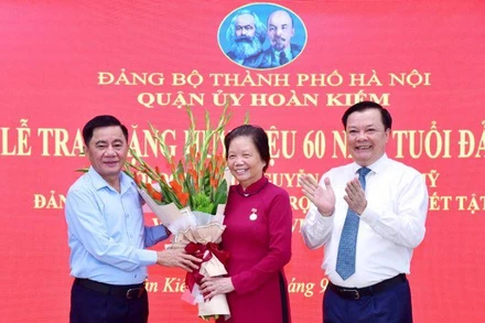 Chủ nhiệm Ủy ban Kiểm tra Trung ương Trần Cẩm Tú và Bí thư Thành ủy Hà Nội Đinh Tiến Dũng tặng hoa chúc mừng đồng chí Nguyễn Thị Xuân Mỹ.