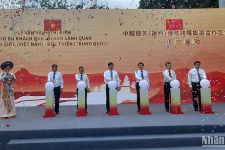 Các đại biểu thực hiện nghi thức vận hành thí điểm cho du khách qua lại tham quan thác Bản Giốc-Đức Thiên.