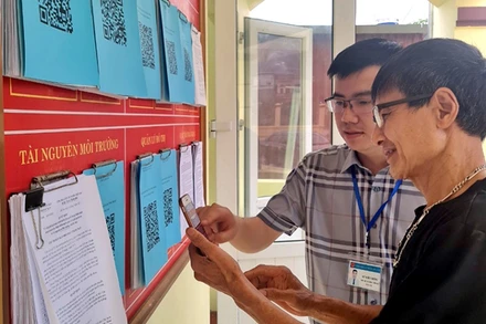 Hướng dẫn nhân dân quét mã QR để tra cứu thủ tục hành chính tại phường Sông Cầu, thành phố Bắc Kạn. (Ảnh: ĐĂNG BÁCH)